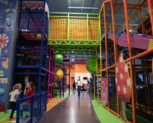 indoor big play structure with two girls laughing