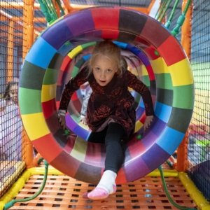 girl climbing through colorful circles