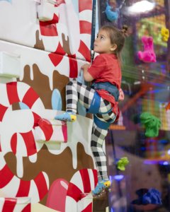 girl climbing candycane wall