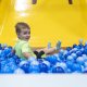 boy sliding into ball pit
